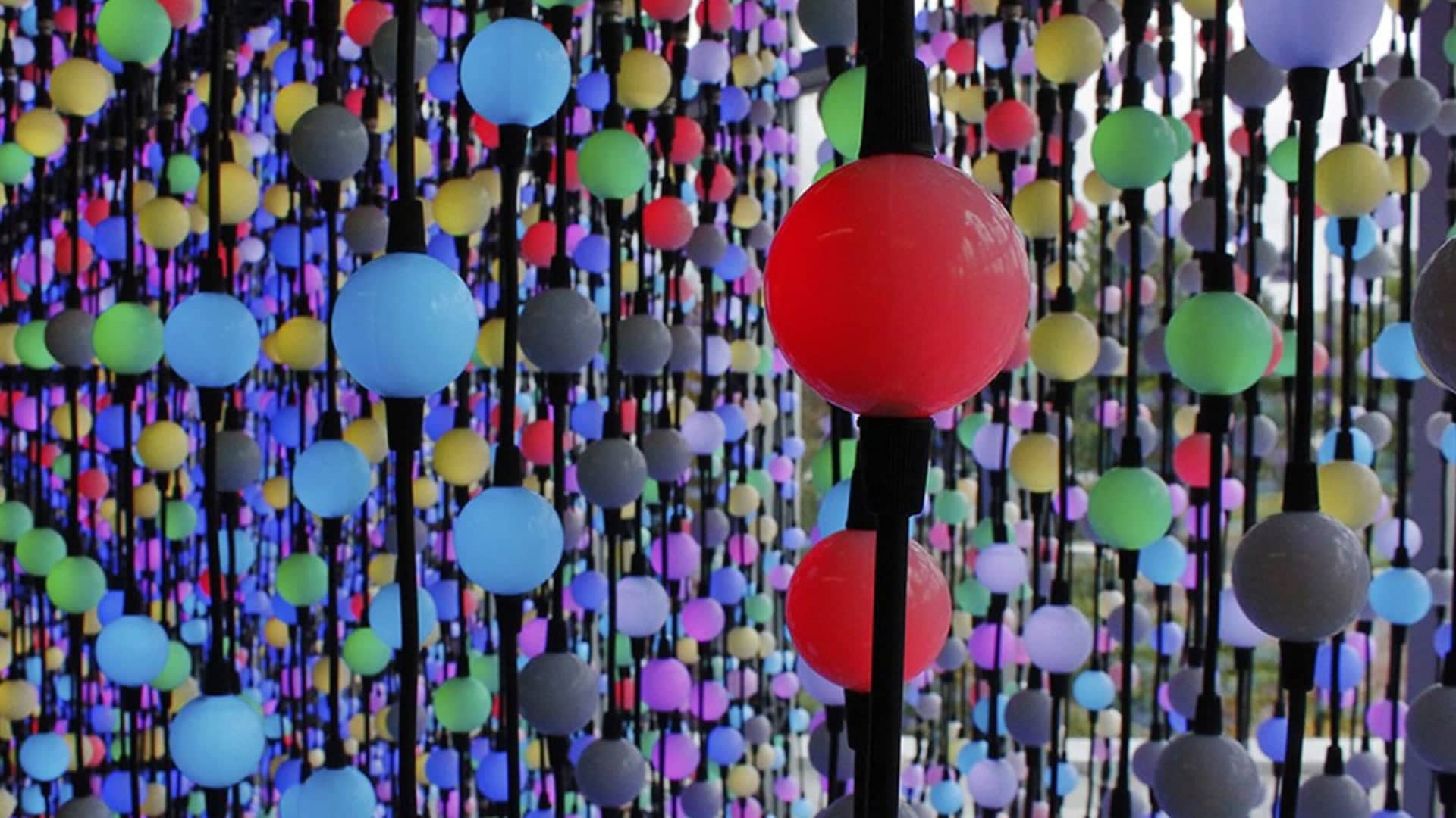 Colorful orbs hang in a 3D LED matrix, forming an immersive interactive installation with vibrant lighting effects.