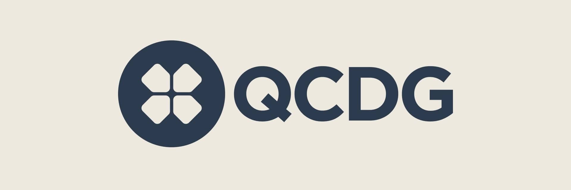 QCDG logo featuring a stylized four-petal flower emblem next to bold letters on a light beige background.
